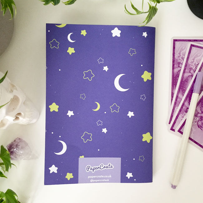 Notebook with celestial pattern of moons and stars on the cover.