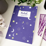 Notebook with celestial pattern of moons and stars on the cover.