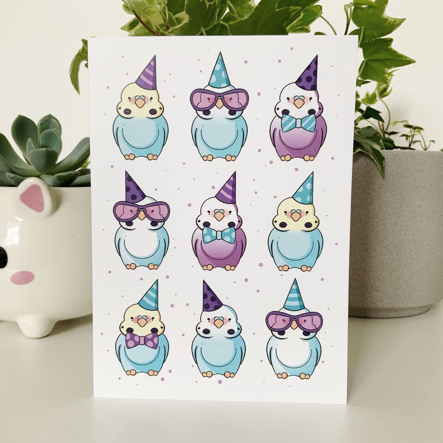 Colorful birthday card featuring budgies wearing tiny hats and bows.