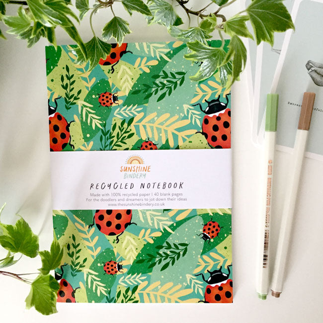 A6-sized notebook with a red and black ladybird cover design.