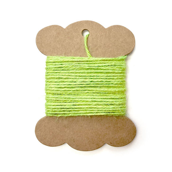 Roll of lime green jute twine on white background.