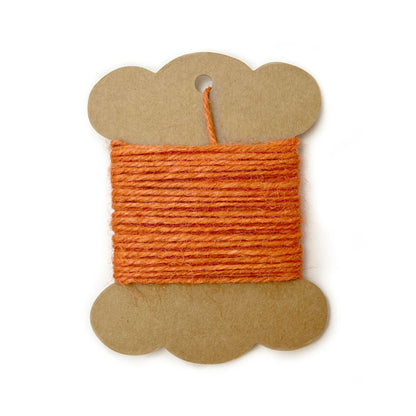 Roll of orange jute twine on white background.