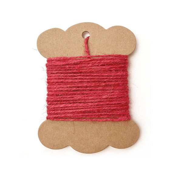 Roll of red jute twine on white background.