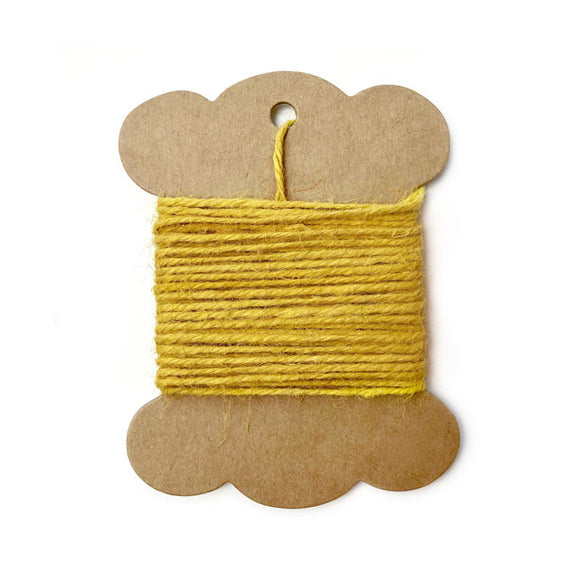 Roll of yellow jute twine on white background.
