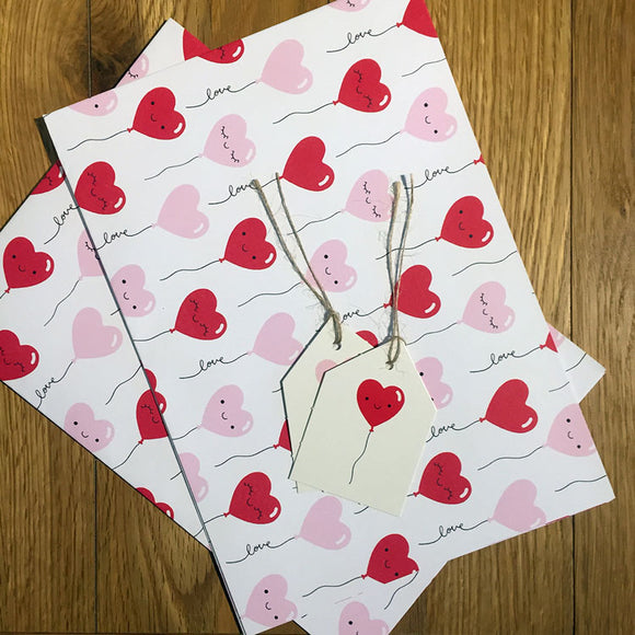Recyclable heart-patterned wrapping paper with matching tags.