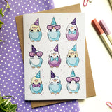 Colorful birthday card featuring budgies wearing tiny hats and bows.