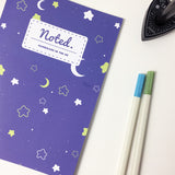 Notebook with celestial pattern of moons and stars on the cover.