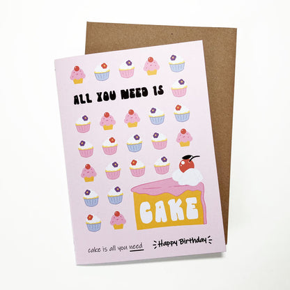 Illustrated birthday card with the phrase "All You Need Is Cake."
