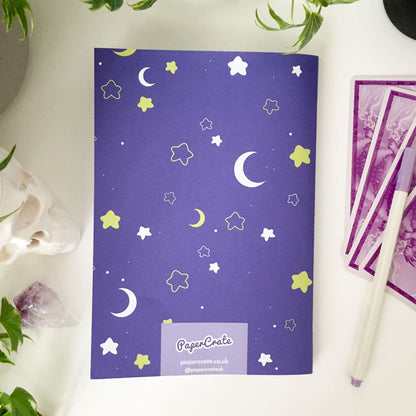 Notebook with celestial pattern of moons and stars on the cover.