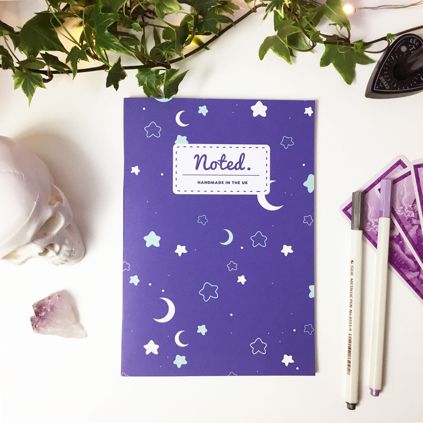 Notebook with celestial pattern of moons and stars on the cover.