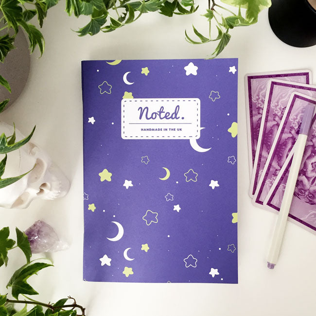 Notebook with celestial pattern of moons and stars on the cover.