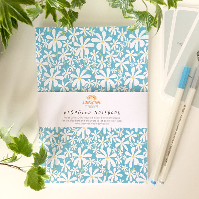 A6-sized notebook with a daisy flower pattern on the cover.