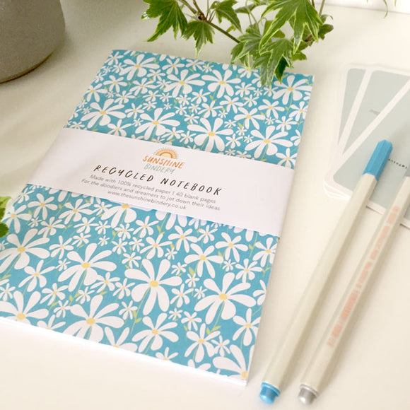 A5-sized notebook with daisy flower design on the cover.