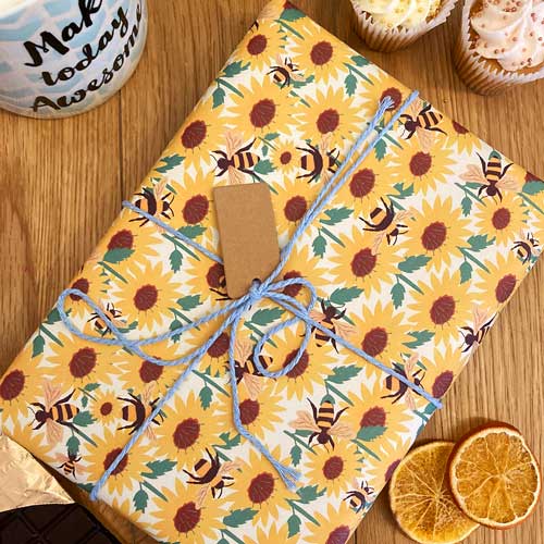 Recyclable wrapping paper with sunflower and bee pattern design.