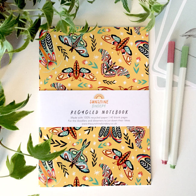 A6-sized notebook with a decorative moth illustration on the cover.
