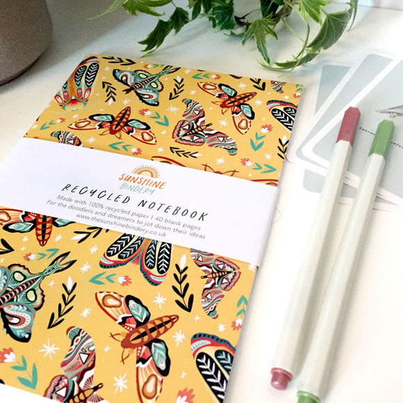 A5-sized notebook with a moth-themed cover design.