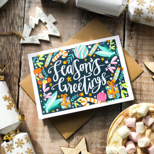 Holiday card with festive design and "Seasons Greetings" message.