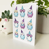 Colorful birthday card featuring budgies wearing tiny hats and bows.